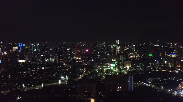 Beautiful aerial footage of night lights in Jakarta city from a drone flying backward