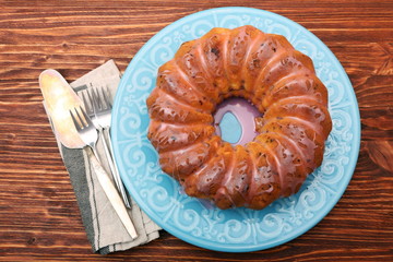 Bundt Cake with Sugar Icing on a wooden background