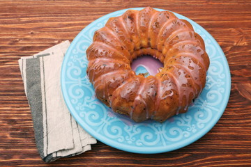 Bundt Cake with Sugar Icing on a wooden background