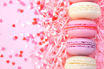 Colorful macarons on bright festive decor background, selective focus, toned