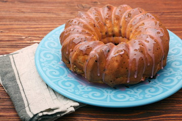 Bundt Cake with Sugar Icing on a wooden background
