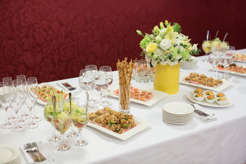 holidays, food, treatment concept. there is gorgeous feast table served for celebration with delicious meal and drinks and decorated of bouquet of adorable flowers