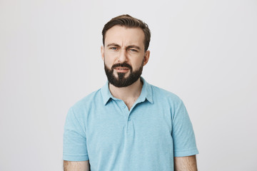 Portrait of a man with facial hair looking confused and questioned. Emotions concept. Guy started attend chinese classes and can not understand a single word his teacher saying to him.