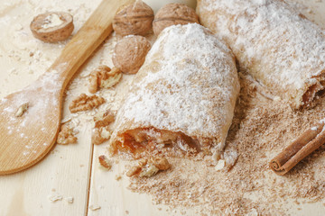 Fototapeta na wymiar Apple strudel with nuts, raisins, cinnamon and powdered sugar.