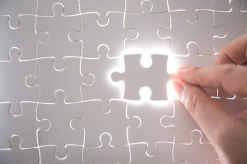  jigsaw puzzle piece with light glow, business concept for completing the final puzzle piece