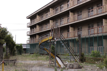 廃墟となった住宅と滑り台