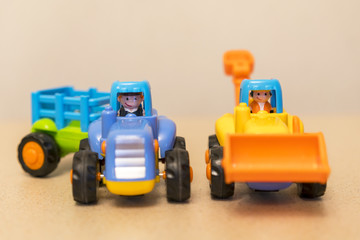 Obraz premium Two bright toy tractor on a light background. The best toys for little boys