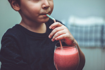 Close up of kid drinking smoothie.