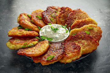 Potato pancakes, draniki, hash browns or fritters served with fresh cream and spring onion