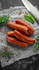Freshly made raw breed butchers sausages in skins with herbs on crumpled paper.