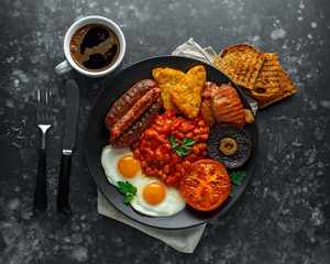 Full English breakfast with bacon, sausage, fried egg, baked beans, hash browns and mushrooms in...