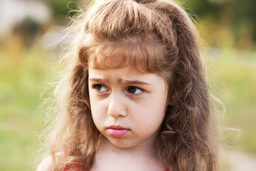 Unhappy beautiful little Girl is crying outdoors