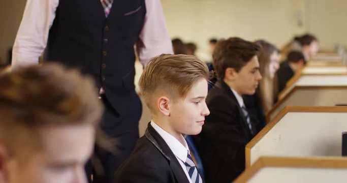 4k,Head teacher has a word with a talkative boy during computer class. Slow motion.