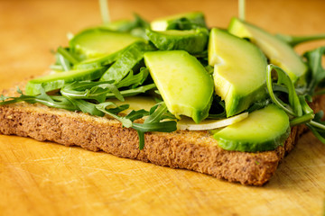 Vegetarian bruschetta with avocado and rucolla od wooden table
