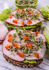 Sandwiches with lettuce, ham and broccoli sprouts.