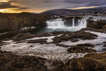 water flowing from frozen godofoss waterfalls, Iceland