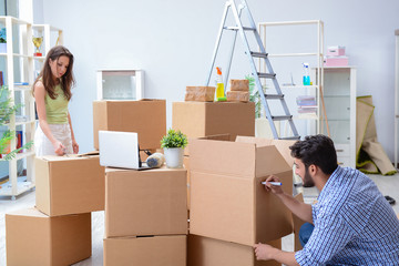 Young family unpacking at new house with boxes