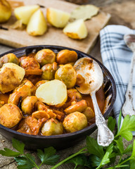 Roasted brussel sprouts with potatoes in homemade ceramic bowl.