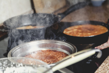 cooking pancakes in several pans