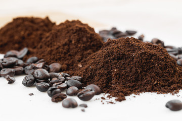 Coffee beans and powder on white background. grinding for espresso and alternative methods of brewing coffee