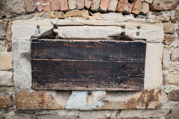 Holzklappe in Mauer aus Stein als Hintergrund mit Textfeld