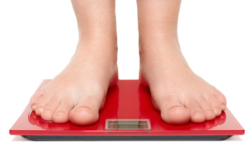 Female bare feet stand on scales. Unrecognizable woman measures her weight, controls everything and care about figure. Diet concept. Isolated shot