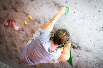 Man climbing hangover boulder in a gym