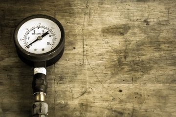 Close up old and rusty pressure gauge on wood background,vintage  style