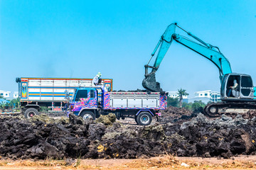 tracked excavator : Digger loading trucks with soil