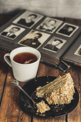 cake - Napoleon (cake with white cream is layered) and photos on a wooden table