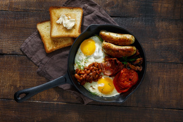 English breakfast on dark wooden background, top view