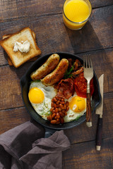 Top view Full English breakfast on dark wooden table