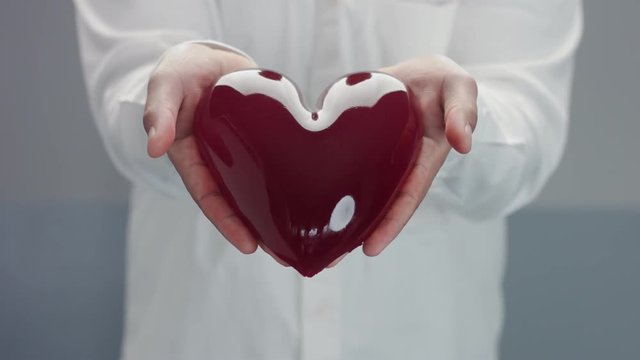mans showing to camera a heart jelly-like in his hands. Open heart concept