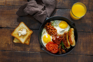 Top view Full English breakfast on dark wooden background