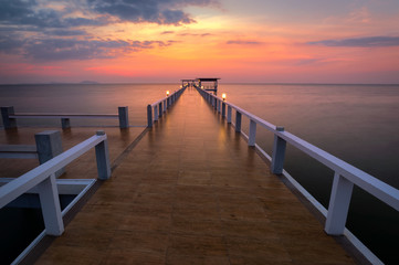 Fototapeta na wymiar Wooded bridge in the port at sunset.