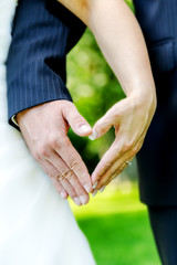 eine Hochzeitspaar bildet mit ihren Händen ein Herz