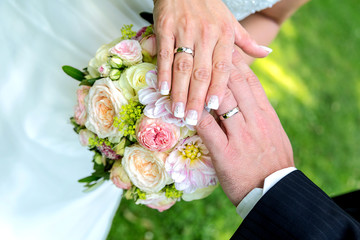 Obraz na płótnie Canvas ein frisch verheiratet Paar zeigt seine Ringe auf dem Brautstrauß