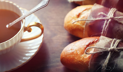 Fresh rolls for breakfast. Bun with butter to a cup of coffee in