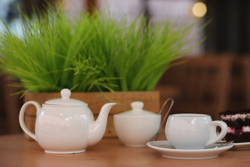 Kettle with a drink and dessert in a street cafe. Tea in the ket