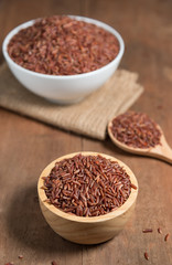 Rice berry in wooden bowl on wood background