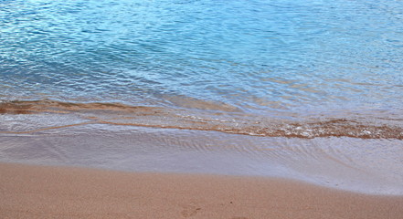 Fototapeta na wymiar Sea beach with wet sand and blue wave splash. Texture. Background