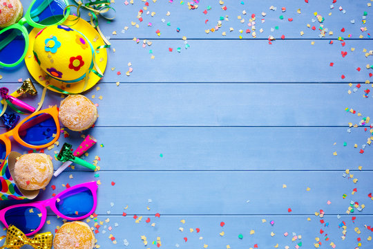 Colorful birthday or carnival border with party items on wooden background