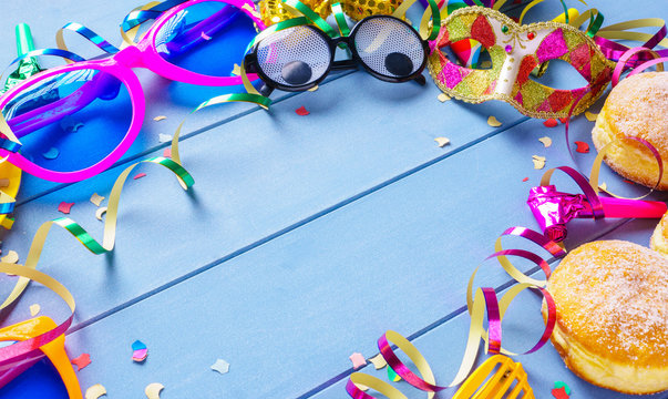 Carnival frame with colorful accessories on blue wooden background