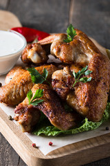 Close-up photo of bbq chicken wings with fries and beer. Barbeques meat with sauces, ketchup, mayonnaise. Fast and junk food concept. 
