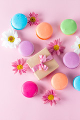 Photo of cake macarons, gift box, tea, coffee, cappuccino and flowers. Sweet romantic food macaroon concept. Morning breakfast and presents.