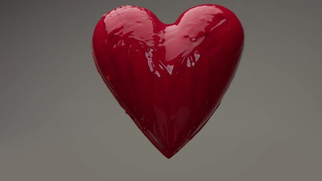 flying red wet heart in air with red transparent liquid covered it and pouring on it. St. Valentine's day heart