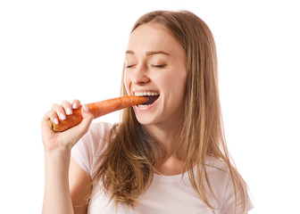 Beautiful young woman holding a carrot in the hands