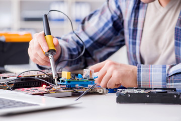 Professional repairman repairing computer in workshop