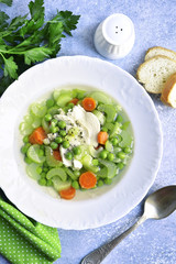 Celery soup with chicken, carrot and green pea.Top view.