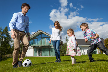 Family playing soccer outside